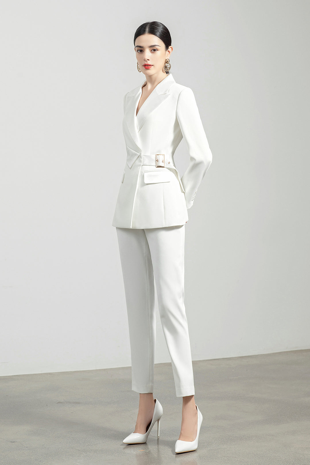 Model wearing Meliora's white Alabaster trouser suit with side pose