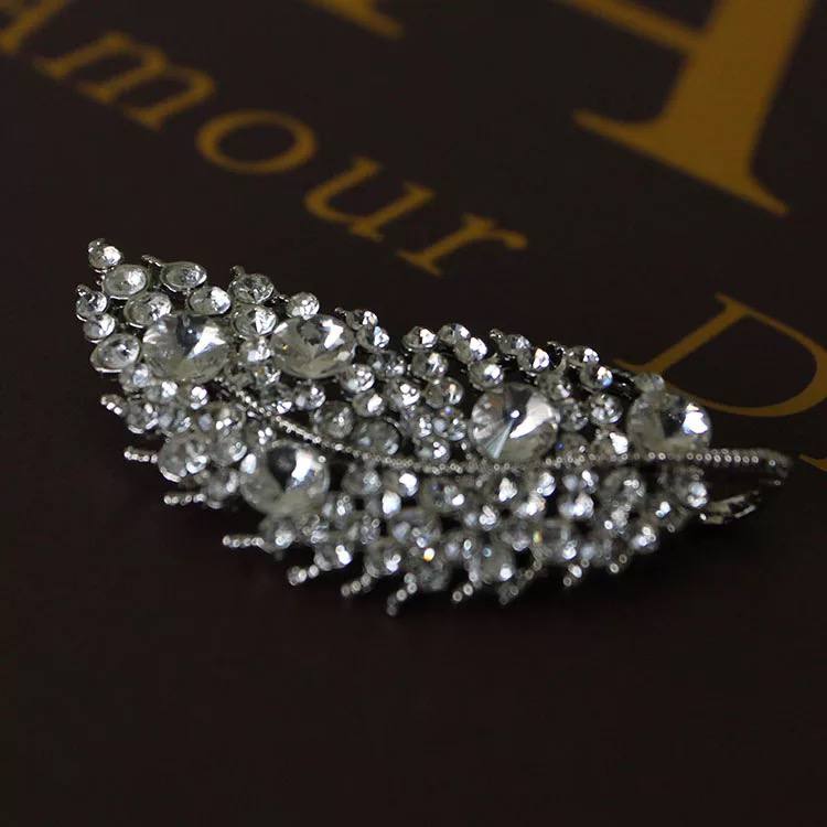 A desirable silver leaf brooch that can add a delicate touch of nature to an evening outfit such as the Meliora White Imperial Blazer Dress.