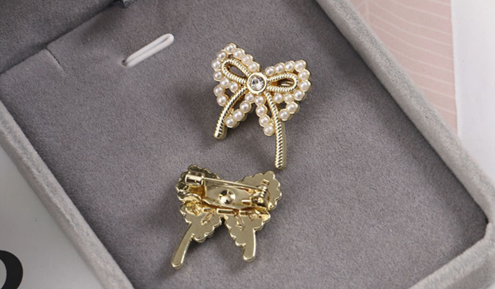 golden bow brooch with pearl detailing and rhinestone centre for an elegant touch to any Christmas party outfit. 