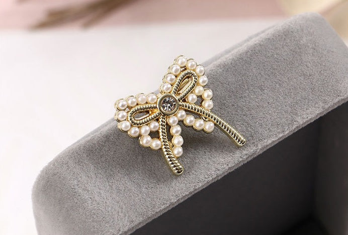 golden bow brooch with pearl detailing and rhinestone centre for an elegant touch to any Christmas party outfit. 